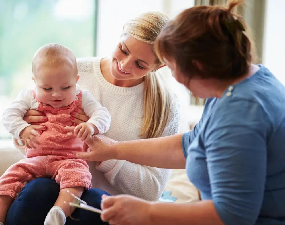 a health visitor supporting a mother and baby