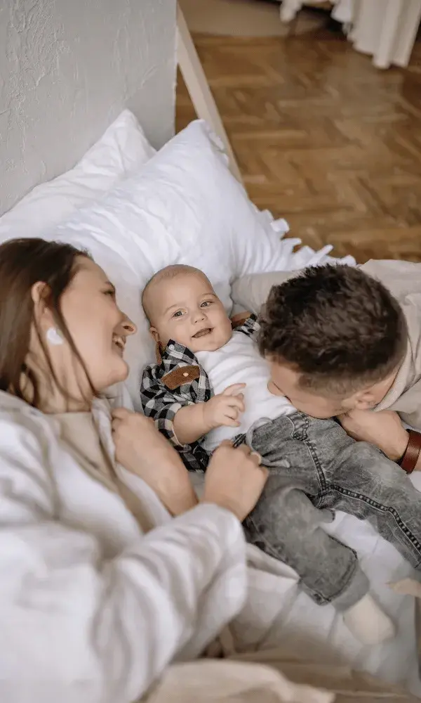 A young mum and dad play with their infant